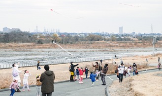 河川敷周辺で凧を飛ばす参加者