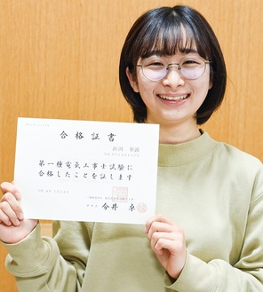 第１種電気工事士の合格証書を手に笑顔の浜田さん＝先月27日、同校