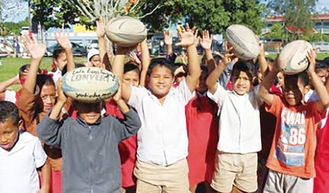 県協会が贈ったボールを持つトンガの子どもたち＝同協会提供