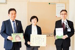 設置された掲示板の前で感謝状を持つ露木会長、石橋さん（左）、藤井区長