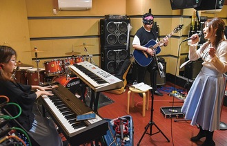 市内のスタジオで練習するなかむらさん(右)らメンバー＝先月24日