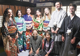 振袖や袴を着て笑顔の留学生、原島理事長（下段左）ら