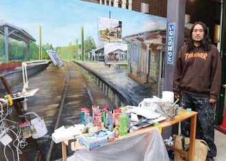 描かれた昔の登戸駅の線路とホーム､亀山さん＝撮影はすべて４月25日
