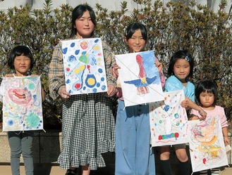 岡本太郎作品をモチーフに描いた自作の凧を持つ子どもたち