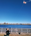 多摩川の河川敷で凧をあげる児童（せせらぎ館提供）