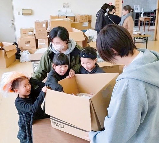 学用品を受け取る子どもたち＝市提供