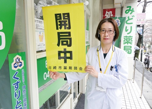 営業を示す旗を持つ佐々木さん