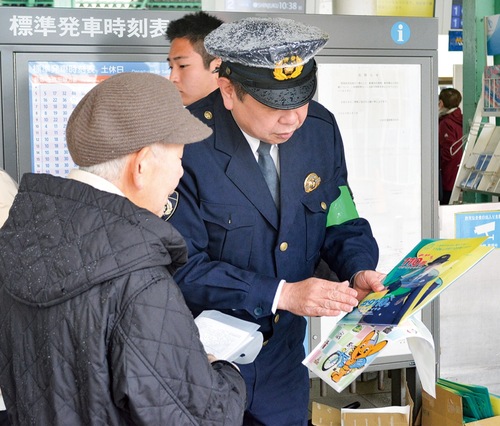 女性に啓発物について説明する警察官