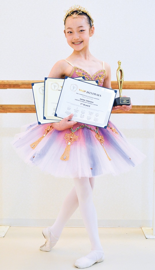 トロフィーと賞状を手に、笑顔を見せる寺田さん