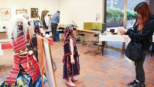 段ボールで作られた甲冑を着て写真を撮る親子