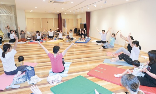 「笑いヨガ」で体を動かす参加者ら