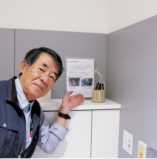 川崎市役所復元棟１階のバリアフリートイレに設置された消臭用の炭を紹介する小泉さん