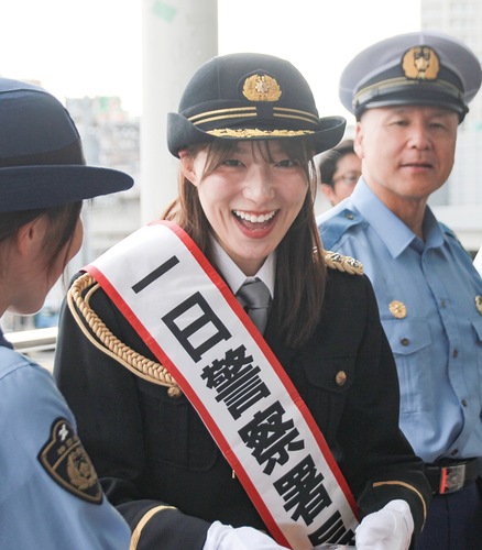 登戸駅で啓発グッズを配布する阿部華也子さん