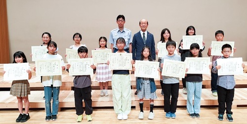 表彰状を受け取った小学生と濃沼会長（後列右から４人目）、佐川署長（同５人目）