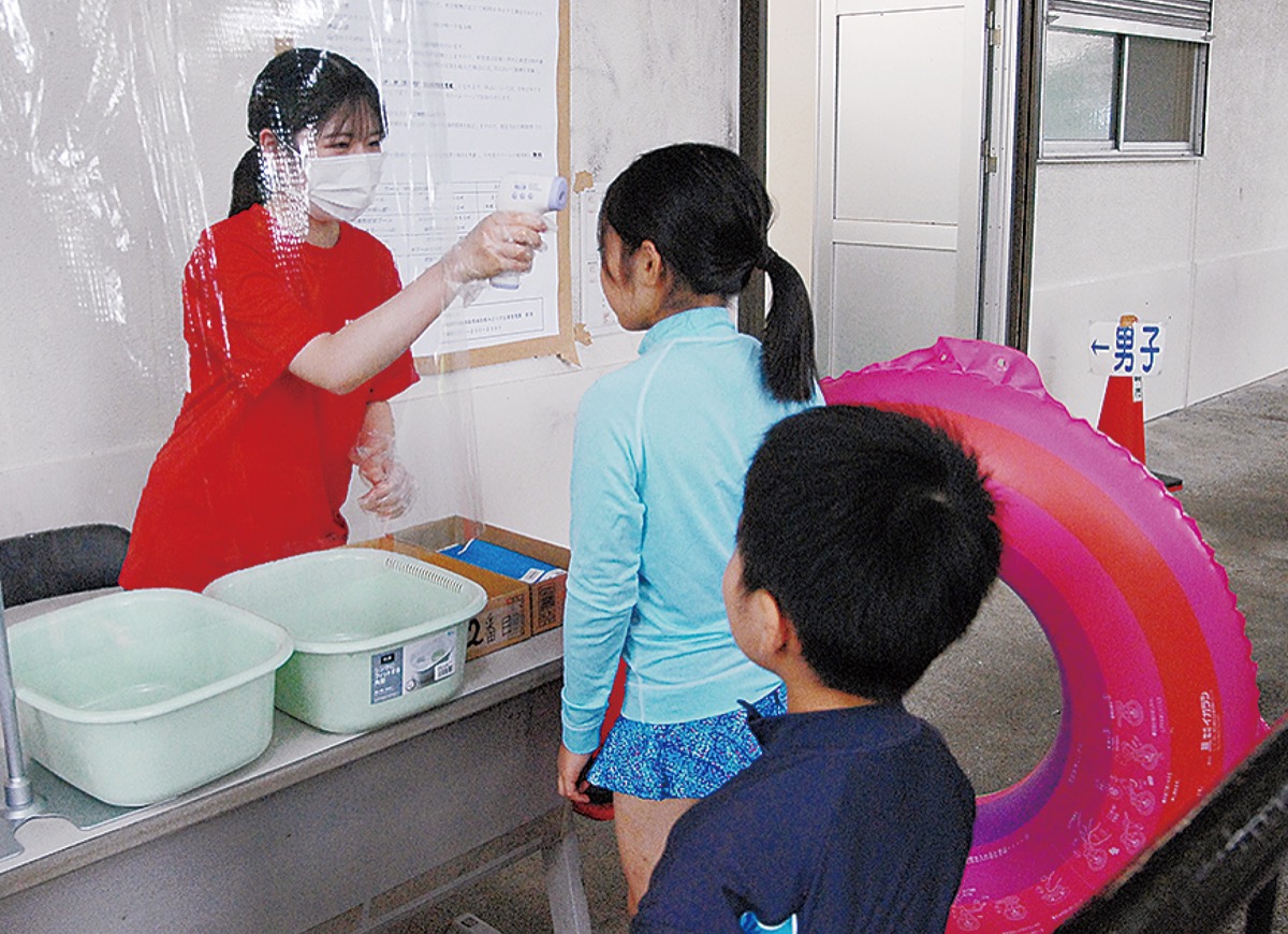 受付で検温する来場者＝１日