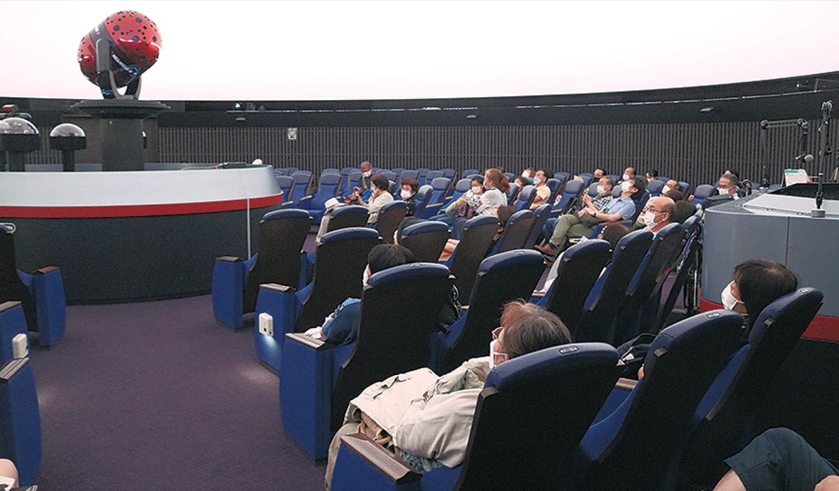 会場の席に着く観覧者