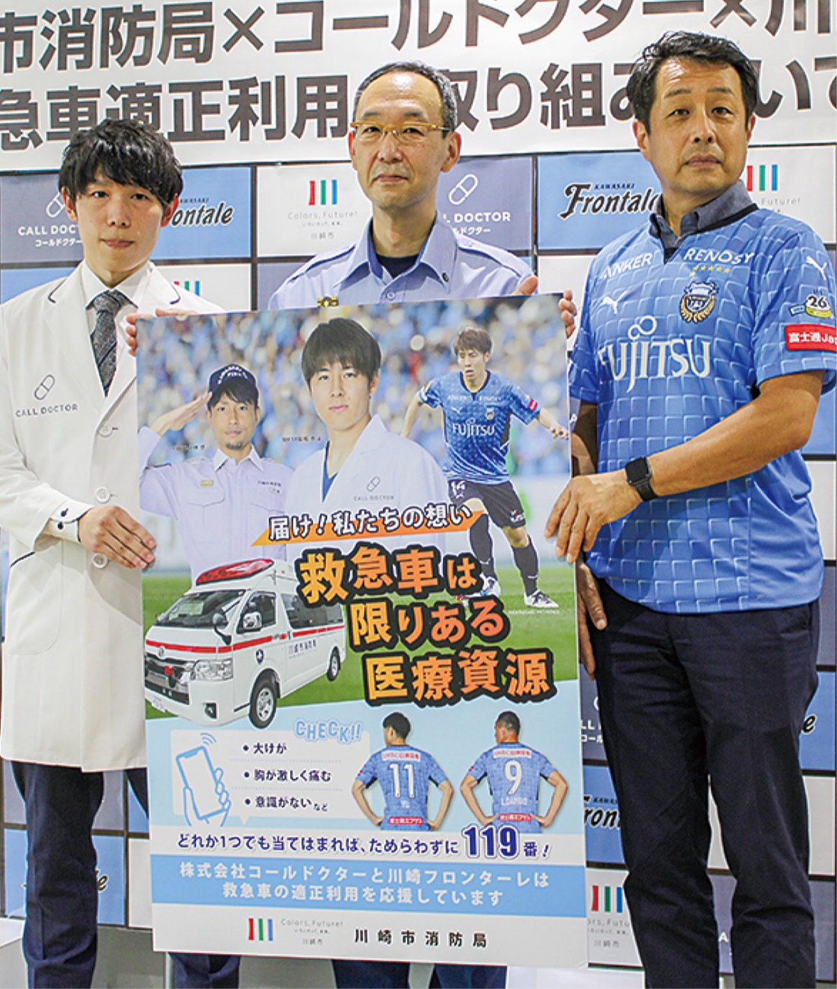 ポスターを手にする関係者