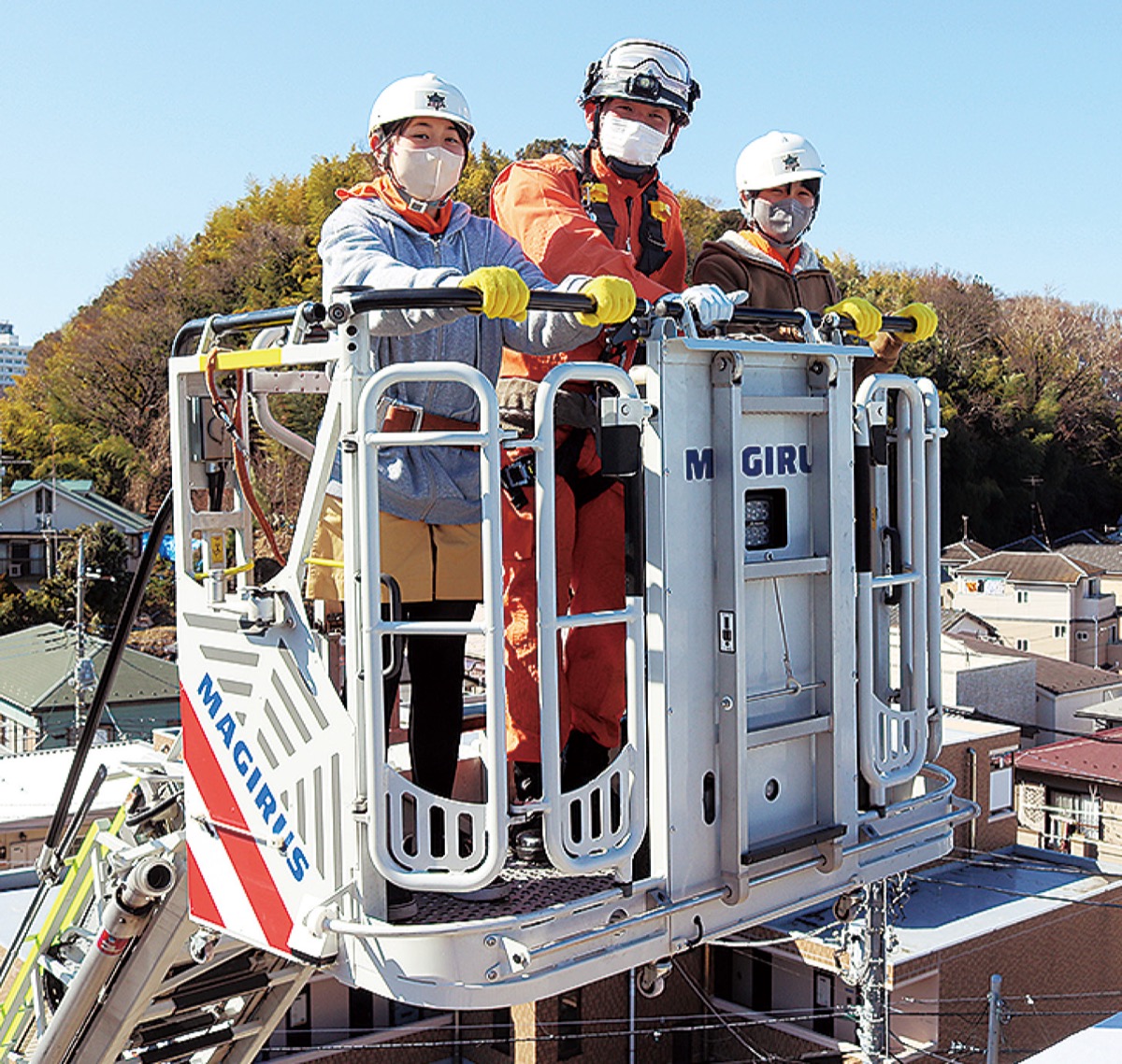 はしご車に乗る児童と消防隊員