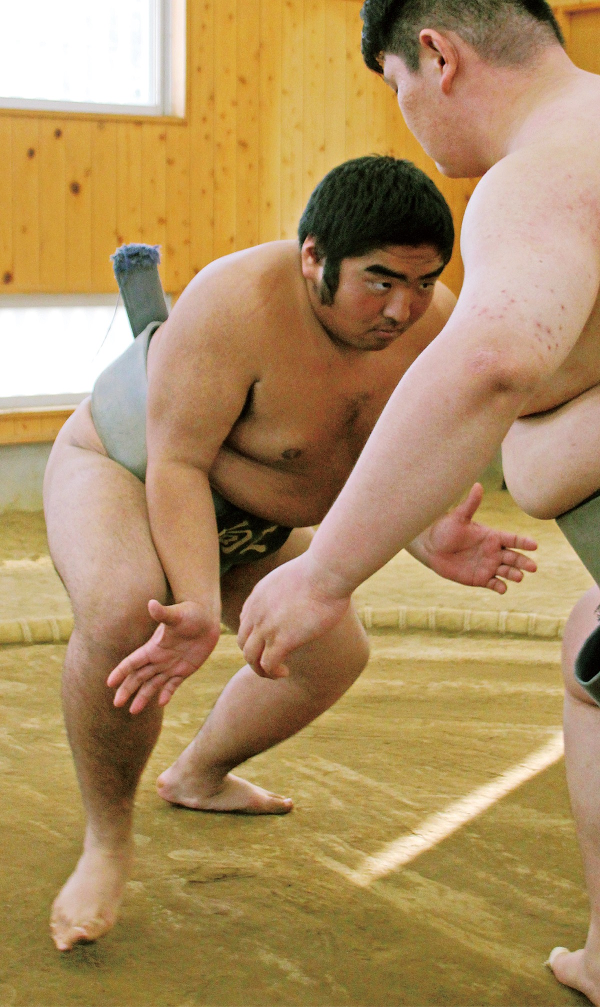 部員とぶつかり稽古をする秋山さん＝12月18日、向の岡工業