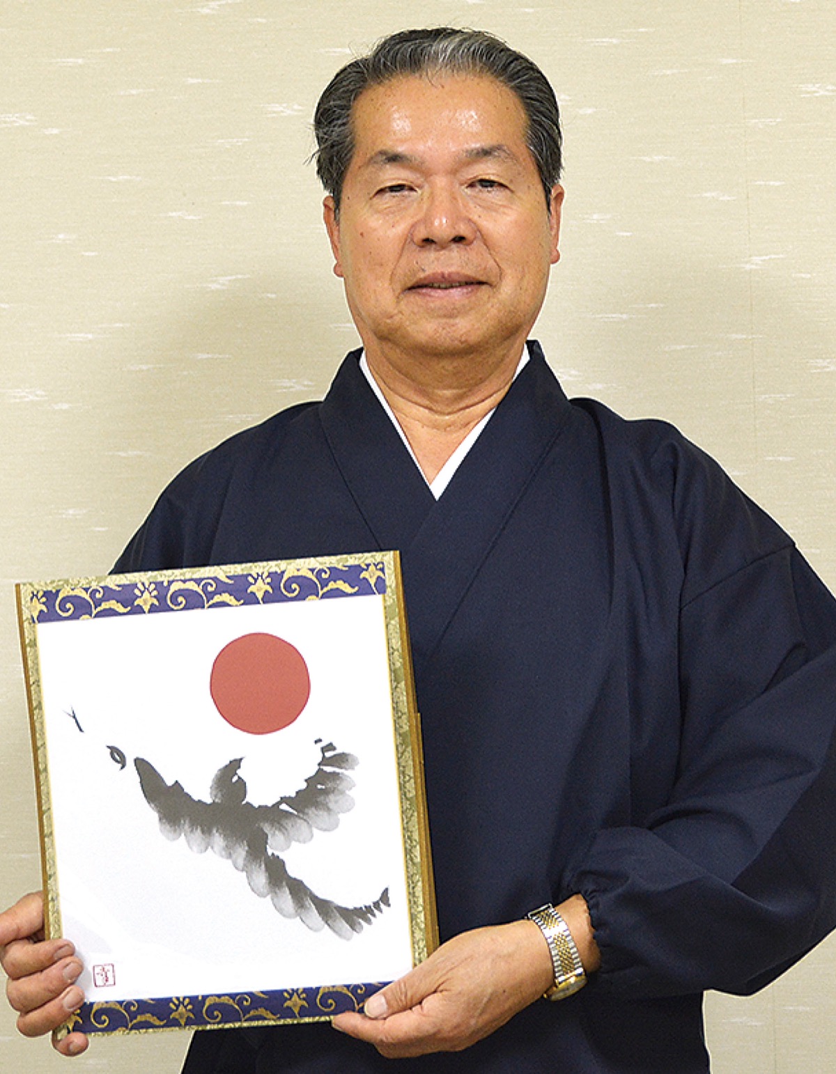 墨絵が描かれた色紙を持つ志村宮司