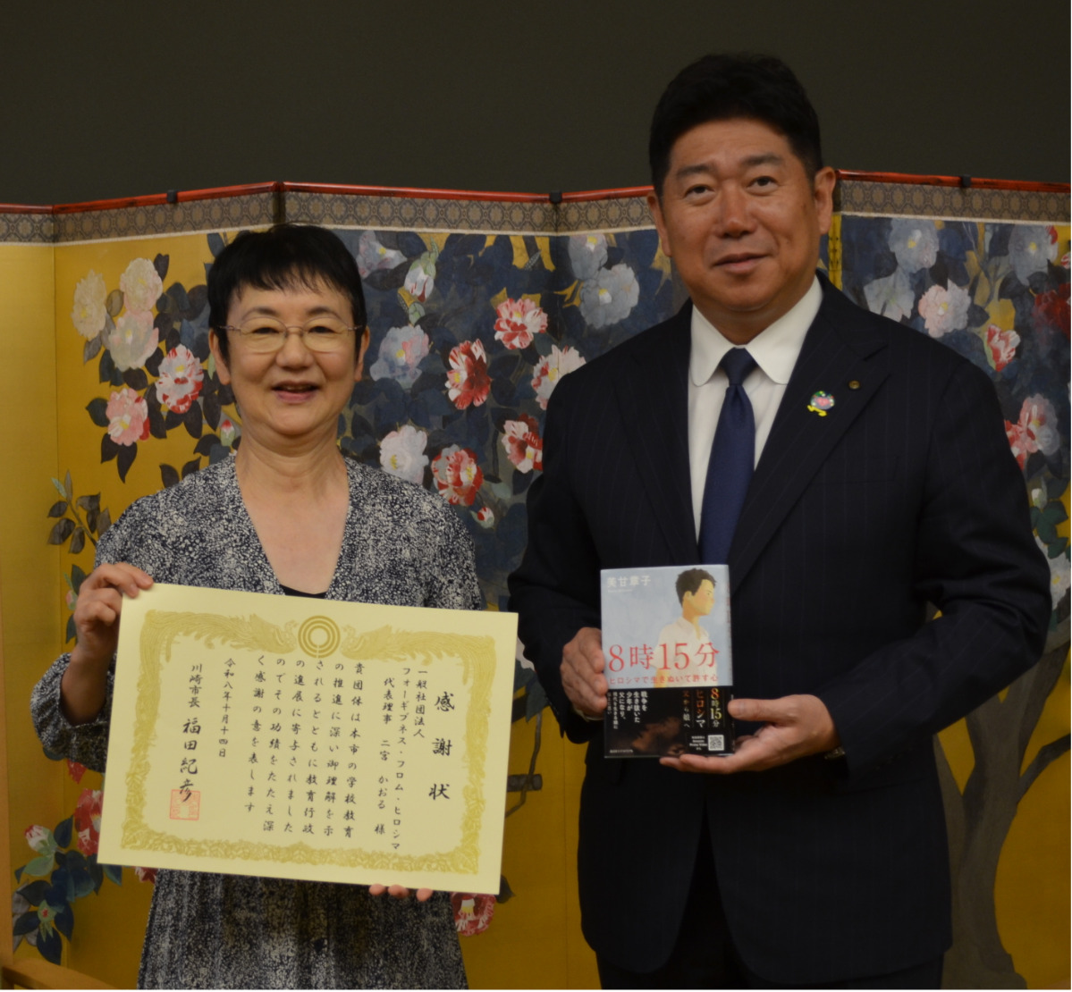 感謝状を持つ二宮代表と同書を手にする福田市長