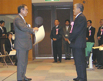 阿部市長から表彰状を受け取る菊池代表取締役