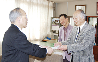 寄付を手渡す石川理事長（右）