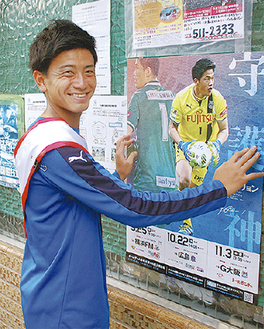 新しいポスターに貼り替える長谷川選手