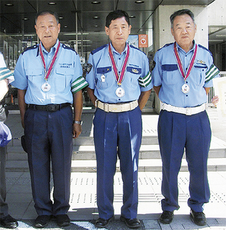 メダルを胸にする（左から）鹿島政美さん、鹿島義久さん、朝比奈さん