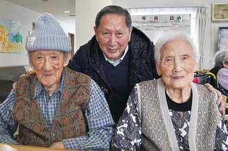 文三郎さん（左）、八重子さん（右）の長寿を労う長男の隆さん