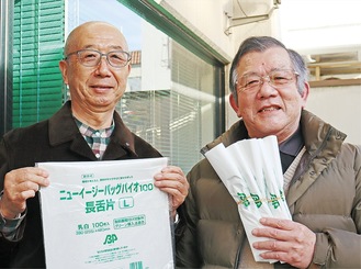袋を持つ内田会長(左)と荻原部長