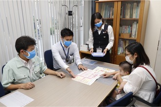 特製マスクを着け、接客する稲田支店の職員＝JAセレサ川崎提供