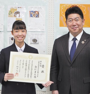 市長から表彰状を受け取り笑顔の奥住さん