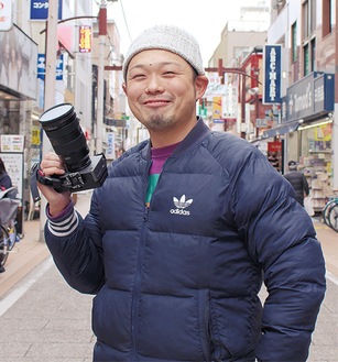 愛用のカメラを手にする松本さん