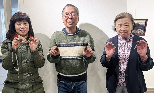 ベーゴマを手に笑顔を見せるまちづくり推進委員会のメンバー