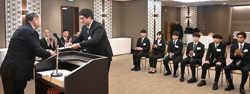 小林会長から発令通知書を受け取る新入社員