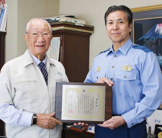菅署長から表彰状を手渡された簑原会長（左）