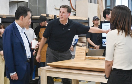 アップサイクルの工程の説明を聞く浅尾環境相(左)