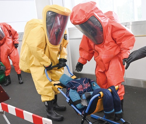 防護服を着て負傷者の搬送訓練を行うレスキュー隊