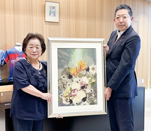 作品を手にする石渡さん（左）と原議長