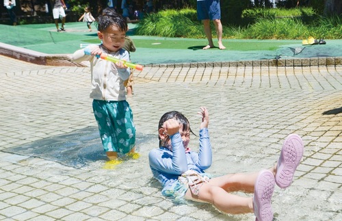 水を掛け合って楽しむきょうだい
