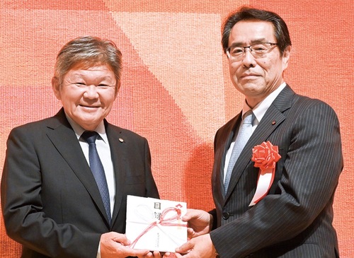 寄付金を手渡す中村支部長（左）