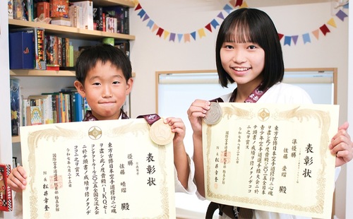 メダルを手に笑顔を見せる二人