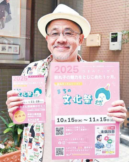 ポスターと冊子を手にする新丸子路地裏連合の久門代表