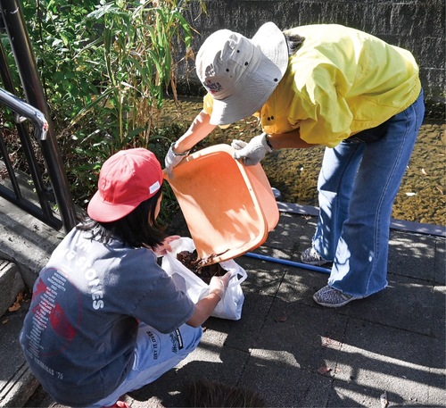 ごみを集めて回る町会会員と児童