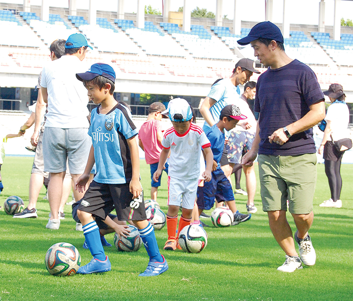 等々力のピッチでボールを追いかける親子
