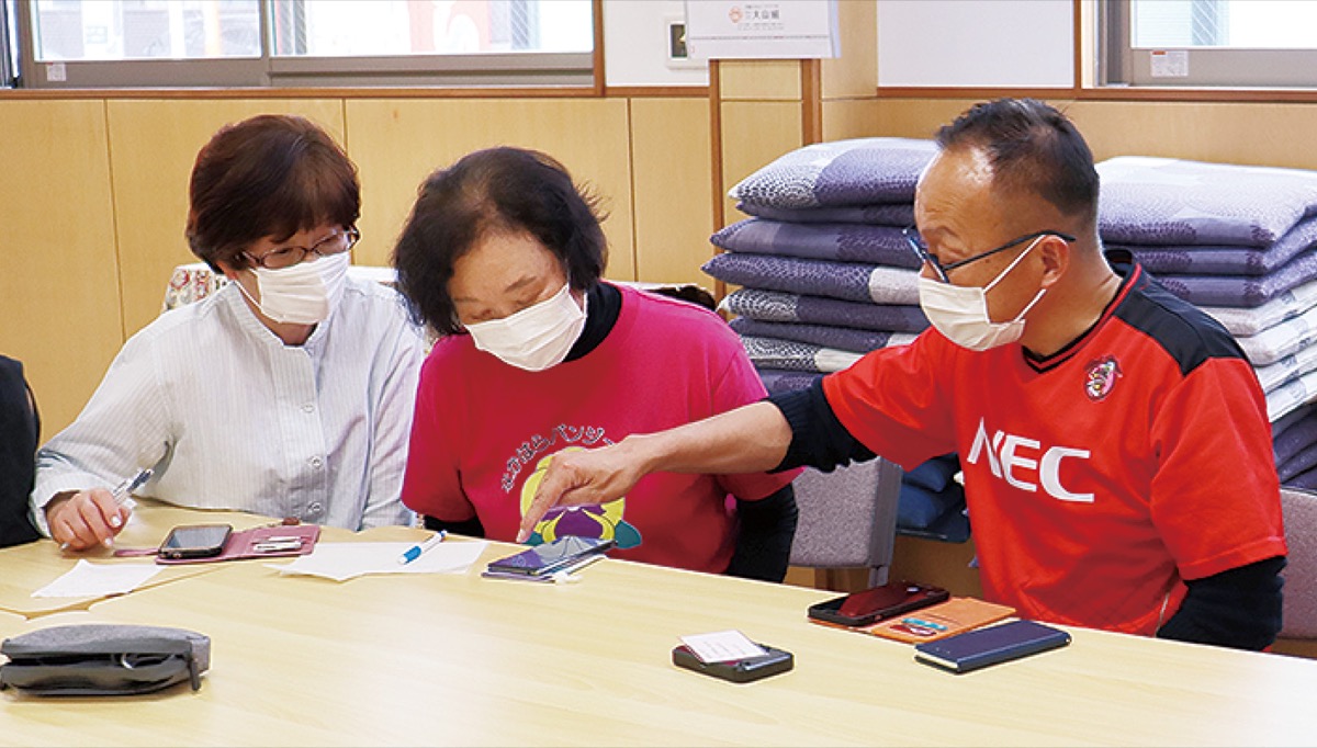 Zoomの使い方を指導するNEC社員(左)