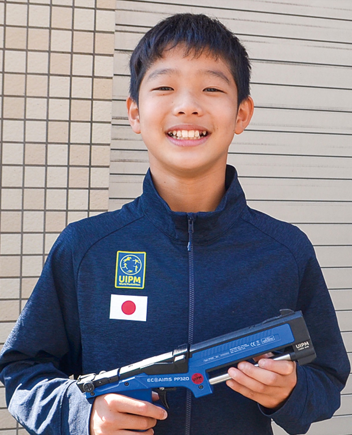 大会でも使用したレーザー銃を手に笑顔の志村さん