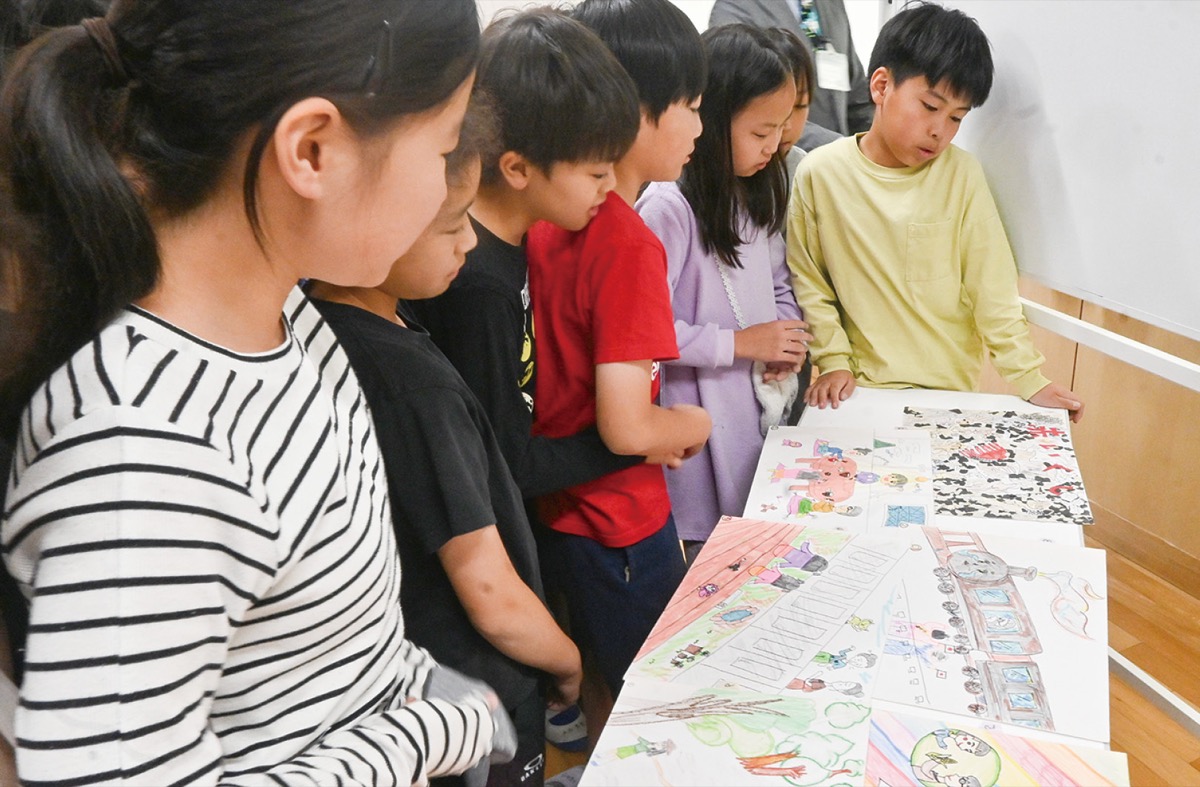 間近で絵を見る児童