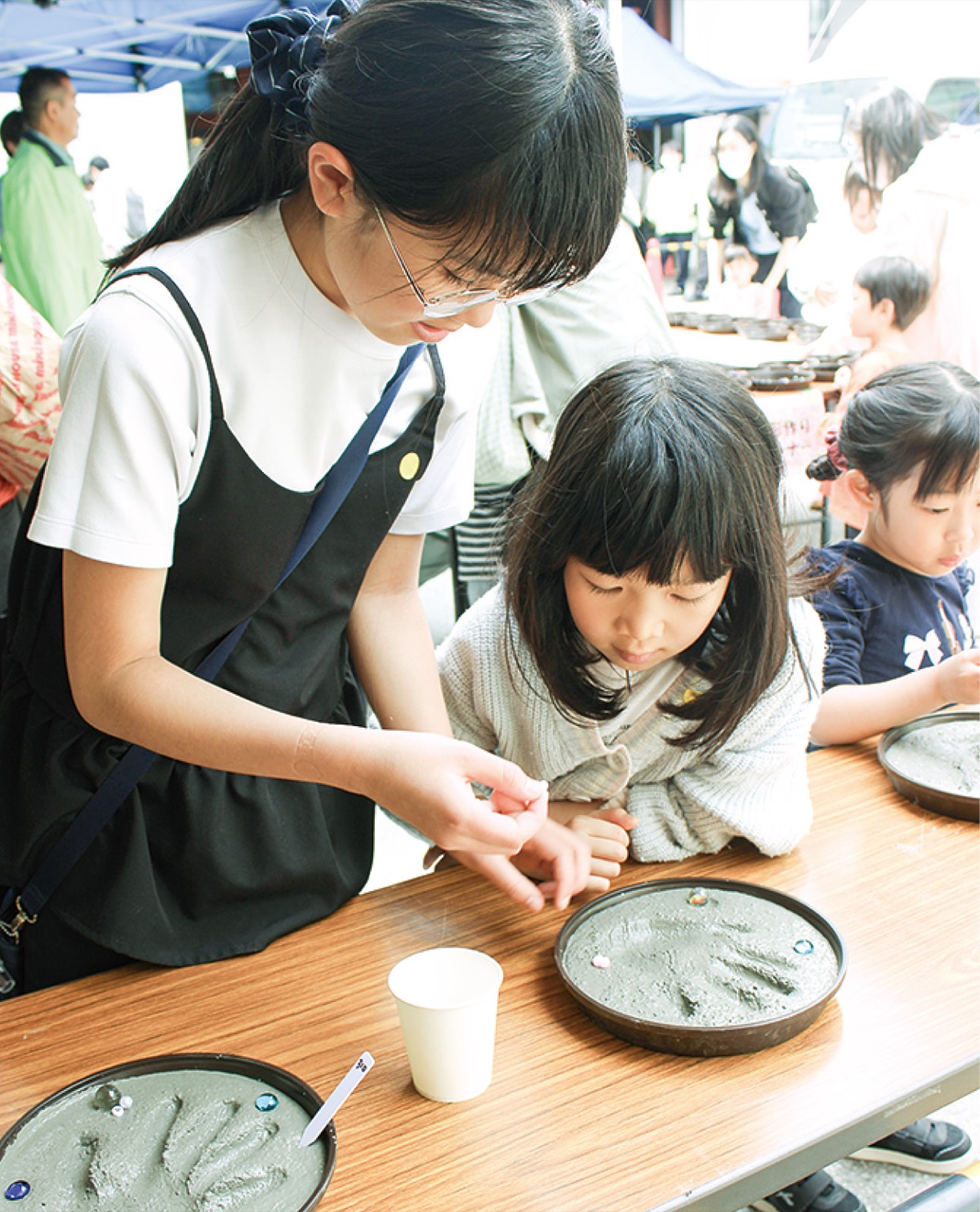 セメントの手形アートづくりを楽しむ姉妹